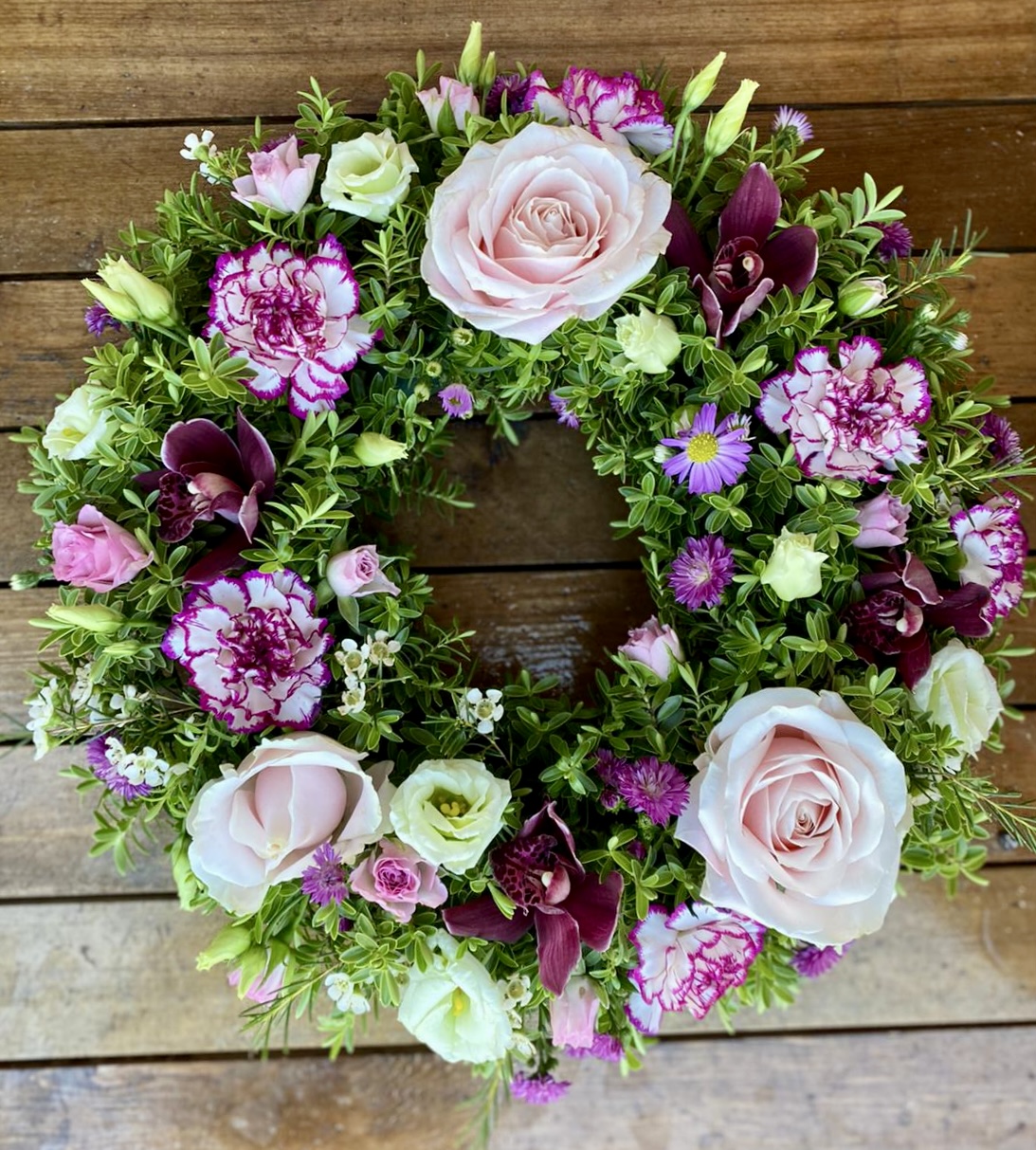 This beautiful lilac and white wreath, symbolising peace and serenity. This elegant arrangement combines lush blue blooms with pure white flowers, offering a heartfelt tribute of respect and remembrance. Perfect for expressing condolences and bringing comfort during a time of loss. Each wreath is carefully crafted to ensure it reflects both beauty and grace during this difficult time.
